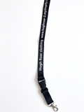 A black fabric strap with white printed text reading 'Hugh Roar clothing' and a website URL, attached to a silver metal lobster clasp.